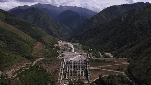 A protective dam against mudflows. Talgar gorge, Tian Shan Mountains. Different vegetation and a mountain river. The view from the drone.