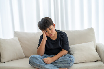 Portrait of sick depressed unhappy child boy touching on head feel suffering head ache pain flu...