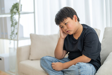 Portrait of sick depressed unhappy child boy touching on head feel suffering head ache pain flu...
