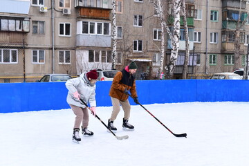 People skate and play ice hockey in the yard