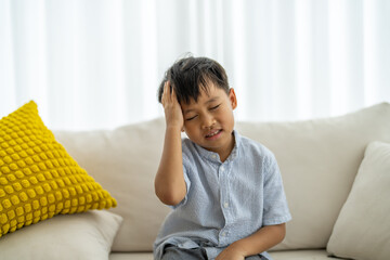 Portrait of sick depressed unhappy child boy touching on head feel suffering head ache pain flu...