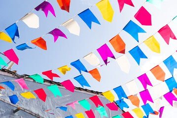 Obraz premium Colorful plastic pennants for decoration against a blue sky.