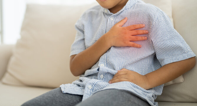 Asian boy with chest pain suffering from heart attack, health and medical, heart health, heart attack, world heart day, cardiovascular disease.insurance and hospital concept