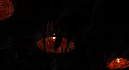 reddish colored lamp lit inside a wooden basket. decoration