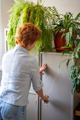 Woman opening a metal safe with stored documents in an office environment. Paperwork security,...