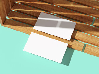 Two business cards aligned on wooden texture, bright background.