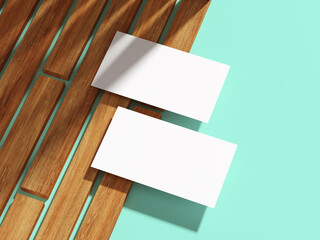A white business card placed diagonally on wooden planks with flat backdrop.