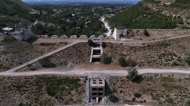 A protective dam against mudflows. Talgar gorge, Tian Shan Mountains. Different vegetation and a mountain river. The view from the drone.