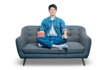 PNG,A relaxed young man in casual attire sits on a sofa holding a bucket of popcorn, ready for a...