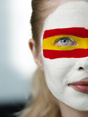 A face adorned with the colors of the Spanish flag symbolizes national pride and the expression of...