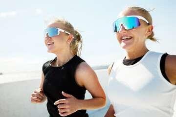 Two friends enjoying a sunny run along the coast, sharing smiles and laughter in the warm afternoon...