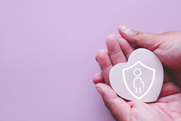 Self-care for pregnant women concept. Hands gently holding a heart shape with a shield and pregnant woman icon, symbolizing the importance of well-being, rest, and mental health during pregnancy.