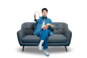 A friendly young man with popcorn on his lap holds up a smartphone with a blank white screen,...