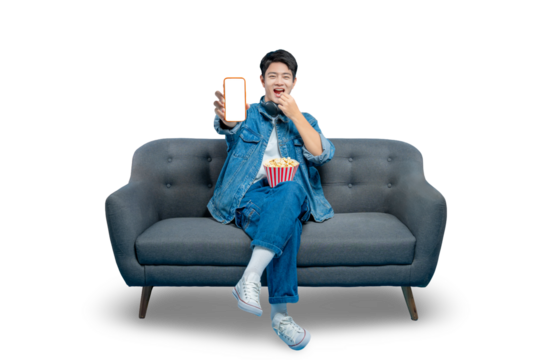 A multitasking young man eats popcorn while showing a smartphone with a blank screen, perfect for food delivery or streaming app concepts.PNG