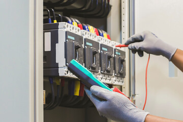 Electrical engineer tests the operation of the electric control cabinet on a regular basis for...