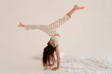 Cheerful funny teenage girl jumping in pajamas having sleepover party with friends. Good mood. Night sleep concept. Selective focus.
