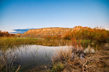 lake in the desert with hills in the background in the evening light