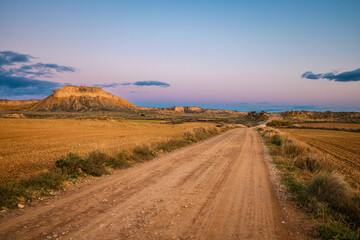 desert road at sunset colored sky