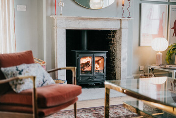 A cozy living room with a fireplace and a red chair