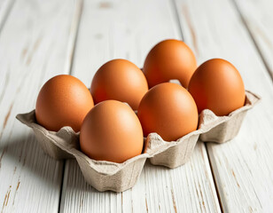 Brown chicken eggs in cardboard tray on wooden table background
