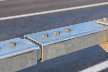 Close-up of metal guardrail segment on urban roadway