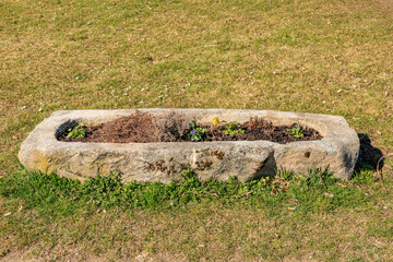 Stone trough planter on a grassy field