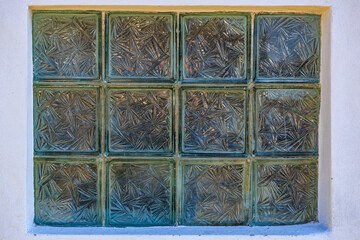 Patterned glass blocks in window frame with geometric designs