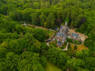 An aerial view of a historic mansion surrounded by lush green trees and a beautifully landscaped...