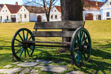 Rustic wooden bench with wagon wheel design in countryside setting