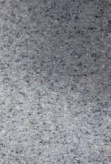 A scanned close-up image of paper printed with a stone-like texture. The surface displays a grainy, irregular pattern.
