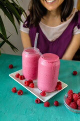 Raspberry Smoothie with a Woman in the Background. Healthy Drink Full of Antioxidants and Vitamins