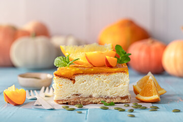 Homemade pumpkin cheesecake decorated with pumpkins and oranges.
