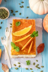 Sweet pumpkin cheesecake decorated with pumpkins and oranges.
