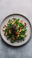 Green salad with nori pieces, pomegranate, and cashew nuts.