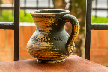 Old clay pot against a blurry background.