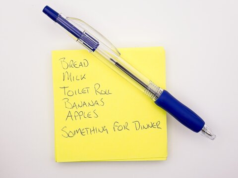 hand written grocery list on post-it note with blue pen