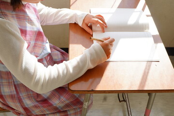机に向かいノートに真剣に書き込む学生、学習に集中する教育現場の光景