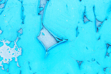 Old blue paint peeling from metal or concrete wall texture background.