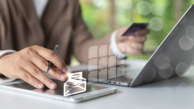 Businesswoman using tablet with stylus and laptop while managing digital documents and making online payment, concept of e-business and email communication.