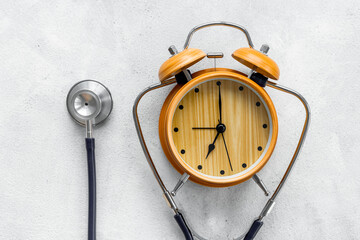 Stethoscope and vintage alarm clock, top view. Time for medical checkup