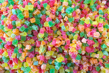 A colorful assortment of small, cubed candied fruits in vibrant shades of green, red, yellow, and orange