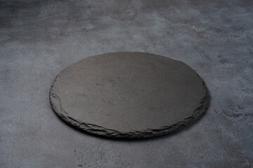 Empty black stone plate on black background