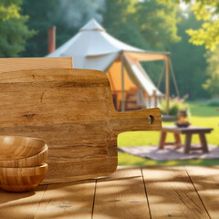 Empty wooden table and copy space for product placement or branding. Blur barbecue grill in garden ...