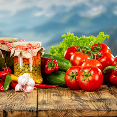 Fresh spring, summer and autumn vegetables on a rustic wooden table with blue sky in the background – healthy seasonal food and natural lifestyle concept.