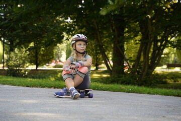 a girl on a skateboard with a helmet in the park