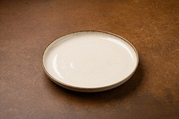 Empty Ceramic Plate on Rustic Stone Table. Minimalist Dining Concept	