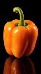 Close-up of orange bell pepper with fresh green stem, vibrant colors against dark blue background, crisp details, natural lighting