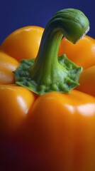 Close-up of orange bell pepper with fresh green stem, vibrant colors against dark blue background, crisp details, natural lighting