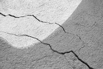 Two big winding descending crack on old plastering wall. Black and white photo. Copy space....
