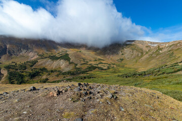 White clouds rolling over the top of a mountain in Rocky Mountain National Park